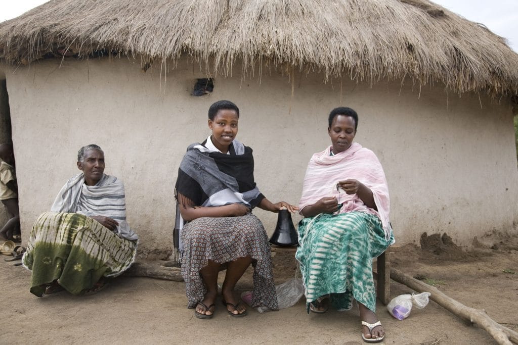 Women from a rural community in Uganda sharing everyday life and local culture during a meaningful travel experience